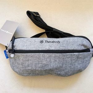 Therabody crossbody bag filled with travel products